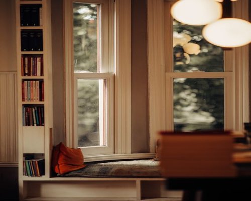 Cozy reading corner near a large window with soft afternoon light