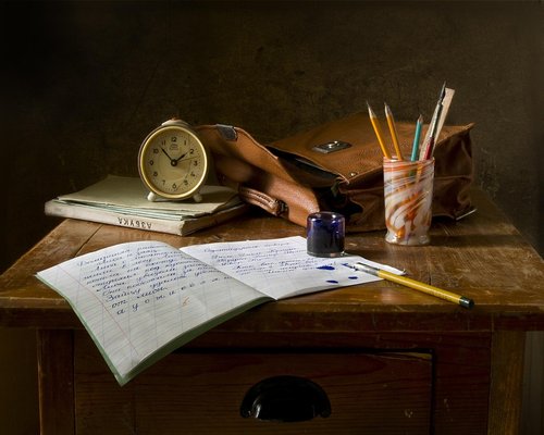 Desk setup illuminated by a warm, soft desk lamp in a dark room